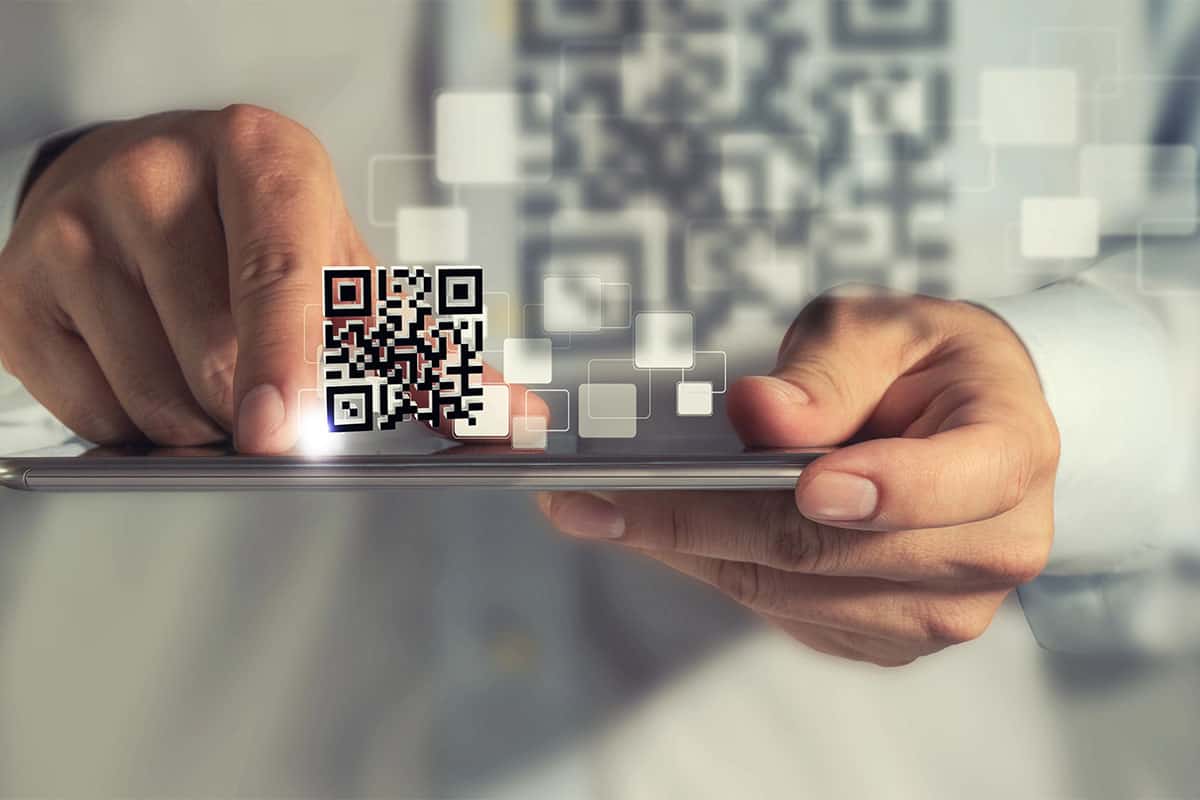 A man scanning a QR code with his phone on San Antonio promotional products.